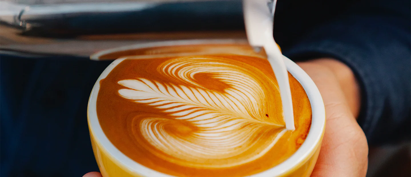Microespuma en jarra de leche lista para verter y practicar latte art